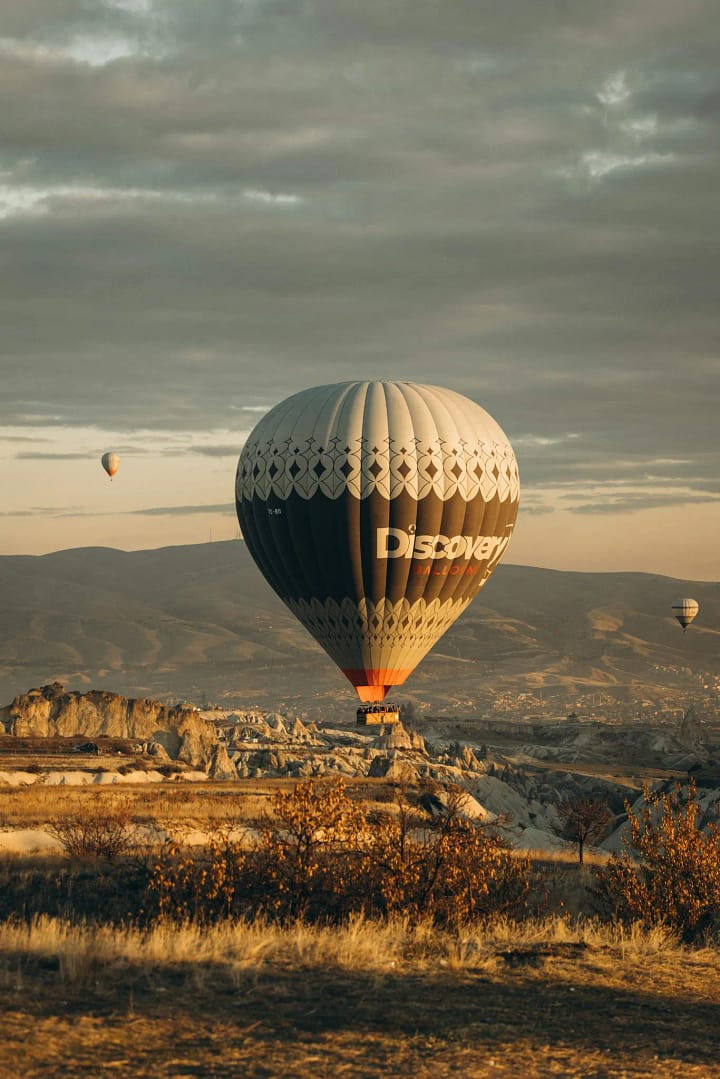Captivating hot air balloon during sunrise in Cappadocia, showcasing the unique landscape of Ürgüp, Türkiye.